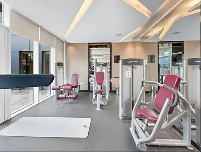 a gym with red chairs and treadmills at Luxury Unit High Floor Damac Majestine in Dubai