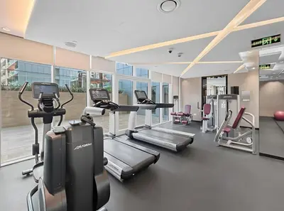 a gym with several treadmills and cardio machines at Luxury Unit High Floor Damac Majestine in Dubai