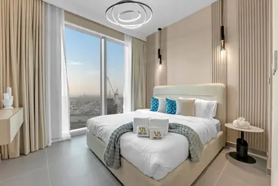 a bedroom with a large bed with a large window at 2BR Luxury Apartment in Downtown Opera in Dubai