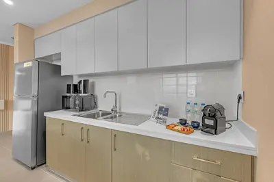 a kitchen with white cabinets and a stainless steel refrigerator at 2BR Luxury Apartment in Downtown Opera in Dubai