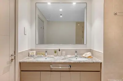a bathroom with a sink and a large mirror at 2BR Luxury Apartment in Downtown Opera in Dubai