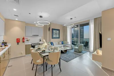 a kitchen and living room with a table and chairs at 2BR Luxury Apartment in Downtown Opera in Dubai