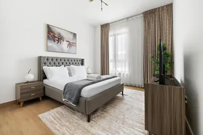 a bedroom with a bed and a television in it at La Mer Le Pont 1 Bedroom Beachside Apartment in Dubai