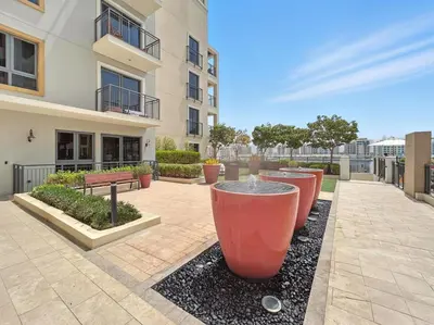 a courtyard with a row of large red pots at La Mer Le Pont 1 Bedroom Beachside Apartment in Dubai