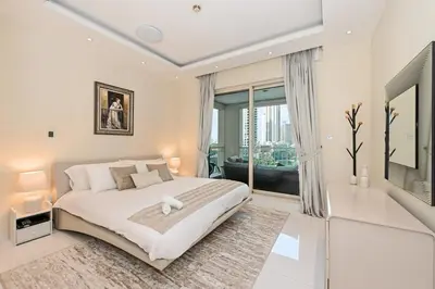 a bedroom with a large bed and a large window at Modern Luxury Upgraded 2BR Apartment The Greens in Dubai