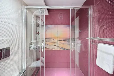 a bathroom with a shower with a painting on the wall at Modern Luxury Upgraded 2BR Apartment The Greens in Dubai