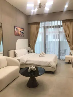 a bedroom with a bed and a couch and a table at Luxury Furnished Studio with Alexa Automation JVC in Dubai