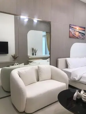 a living room with a white couch and a mirror at Luxury Furnished Studio with Alexa Automation JVC in Dubai