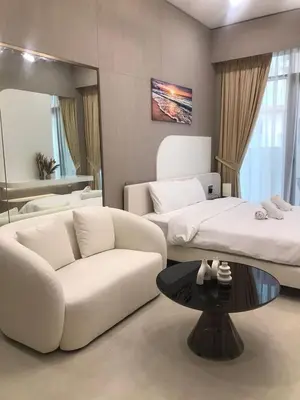 a living room with two beds and a couch and a table at Luxury Furnished Studio with Alexa Automation JVC in Dubai