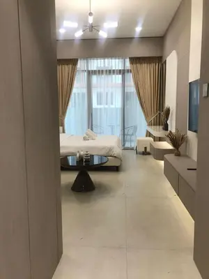 a bedroom with a bed and a coffee table at Luxury Furnished Studio with Alexa Automation JVC in Dubai