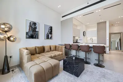 a living room with a couch and a kitchen at Binghatti Phantom luxury living 5 stars amanities in Dubai