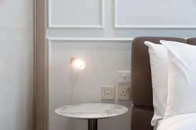 a bed room with a table next to a bed at Binghatti Phantom luxury living 5 stars amanities in Dubai