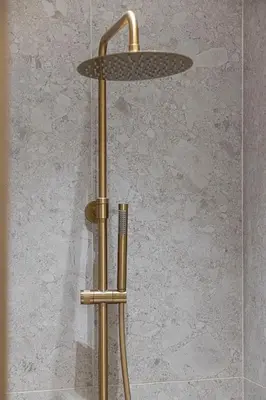 a shower with a gold shower head in a bathroom at Binghatti Phantom luxury living 5 stars amanities in Dubai