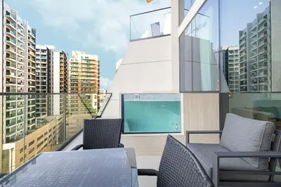 a balcony with chairs and a swimming pool on a building at Binghatti Phantom luxury living 5 stars amanities in Dubai