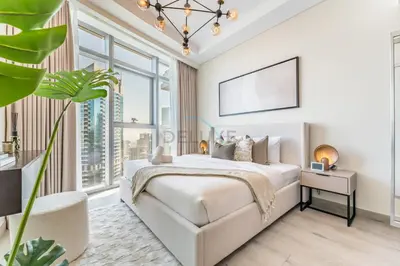 a white bedroom with a bed and a large window at Walking Distance to Dubai Mall and Burj Khalifa, Easy Access to Dubai Marina, JBR Beach and Palm Jumeirah - Imperial Avenue, Downtown Dubai in Dubai
