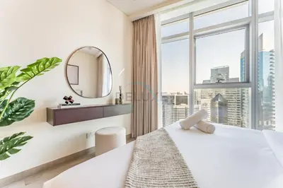 a white bedroom with a large window and a mirror at Walking Distance to Dubai Mall and Burj Khalifa, Easy Access to Dubai Marina, JBR Beach and Palm Jumeirah - Imperial Avenue, Downtown Dubai in Dubai