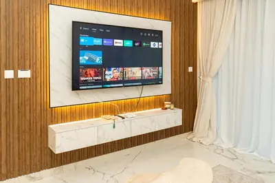 a living room with a television on a wall at 1Luxury Newbedroom nearBusiness Bay in Dubai