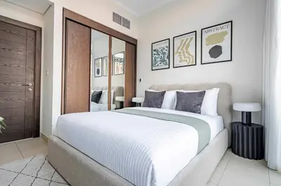 a bedroom with a large bed with white sheets at Frank Porter - Silverene Towers in Dubai