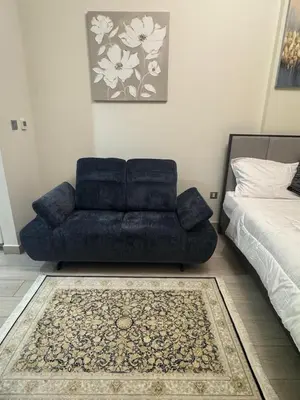 a blue couch sitting in a living room next to a bed at Sophisticated Studio Designer Interiors in Dubai