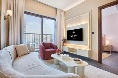 a living room with a couch and a tv at STAY BY LATINEM Luxury 1BR Holiday Home CC 0913 Near Burj Khalifa in Dubai