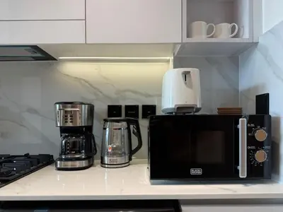a kitchen counter with a coffee maker and a microwave at Modern Studio at Binghatti Azure In Heart of JVC in Dubai