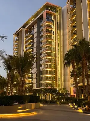 a large building with palm trees in front of it at Luxury Bluewaters Residence in Dubai