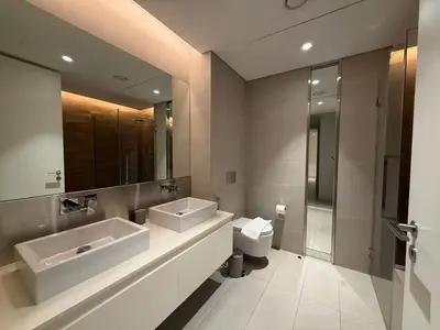 a bathroom with two sinks and a toilet and a mirror at Luxury Bluewaters Residence in Dubai