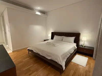 a bedroom with a bed with white sheets and wooden floors at Luxury Bluewaters Residence in Dubai
