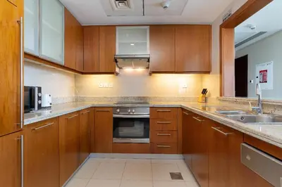 a kitchen with wooden cabinets and a sink at Rustic Retreat in Standpoint, Heart of Downtown in Dubai