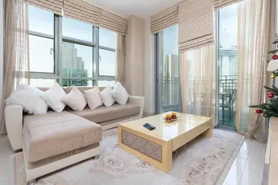 a living room with a couch and a christmas tree at Rustic Retreat in Standpoint, Heart of Downtown in Dubai