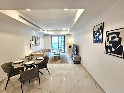 a living room with a table and chairs and a couch at Beautiful 1-BR next to Barasti Beach in Dubai