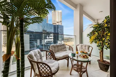 a balcony with chairs and a table in front of a window at BLVD Cozy Stay with Balcony View 10mn to Downtown in Dubai