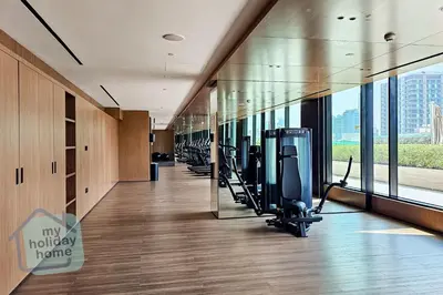 a gym with treadmills and exercise equipment in a building at Modern 1BR Apt - Parking - Gym - Play Area in Dubai