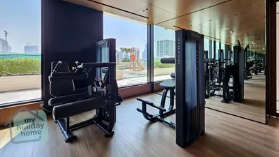 a gym with several tread machines in a room at Modern 1BR Apt - Parking - Gym - Play Area in Dubai