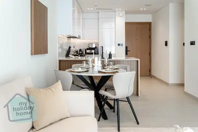 a dining room and kitchen with a table and chairs at Modern 1BR Apt - Parking - Gym - Play Area in Dubai