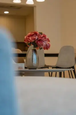 a vase filled with pink flowers sitting on a table at Nivis find- Bay square -1 BHK in Dubai
