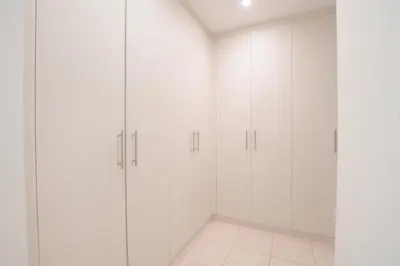 a white walk in closet with white cabinets at Nivis find- Bay square -1 BHK in Dubai