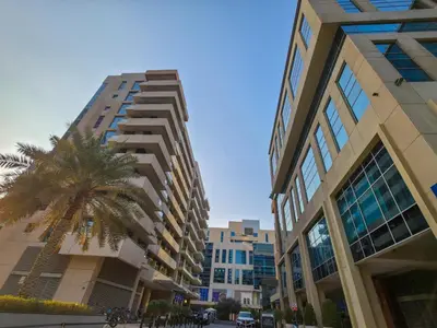 a palm tree in front of a tall building at Nivis find- Bay square -1 BHK in Dubai