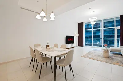 a dining room and living room with a table and chairs at Nivis find- Bay square -1 BHK in Dubai