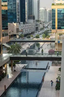 a bridge over a river in a city with buildings at Nivis find- Bay square -1 BHK in Dubai