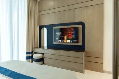 a hotel room with a bed and a tv at The Royale Beige Jacuzzi Suite 36 2-4 I JVC I Dar Oasis in Dubai
