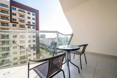 a balcony with a table and chairs and a window at Studio with Seamless Mall Access, Steps from the Bus Stop, Binghatti Stars, Dubai Silicon Oasis by Deluxe Holiday Homes in Dubai