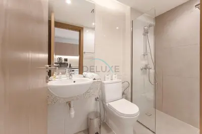 a bathroom with a toilet and a sink and a shower at Studio with Seamless Mall Access, Steps from the Bus Stop, Binghatti Stars, Dubai Silicon Oasis by Deluxe Holiday Homes in Dubai