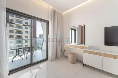 a living room with a tv and a large window at Studio with Seamless Mall Access, Steps from the Bus Stop, Binghatti Stars, Dubai Silicon Oasis by Deluxe Holiday Homes in Dubai
