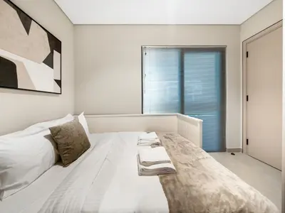 a white bedroom with a large bed and a window at LUX 4BD Villa, PS5, Minutes from Golf & Downtown in Dubai