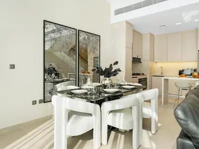 a kitchen and dining room with a table and chairs at LUX 4BD Villa, PS5, Minutes from Golf & Downtown in Dubai