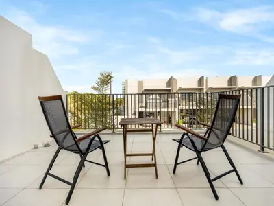 a patio with two chairs and a table on a balcony at LUX 4BD Villa, PS5, Minutes from Golf & Downtown in Dubai