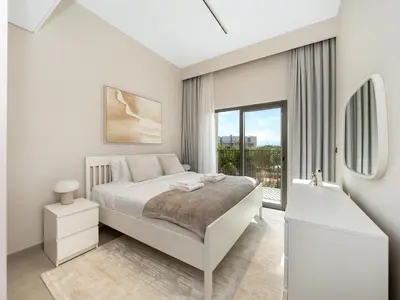 a white bedroom with a bed and a window at LUX 4BD Villa, PS5, Minutes from Golf & Downtown in Dubai