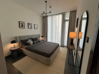 a bedroom with a bed and a large window at Deluxe 1BR with maid's room, 10 min to Downtown in Dubai