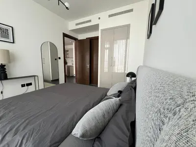 a bedroom with a bed and a mirror at Deluxe 1BR with maid's room, 10 min to Downtown in Dubai